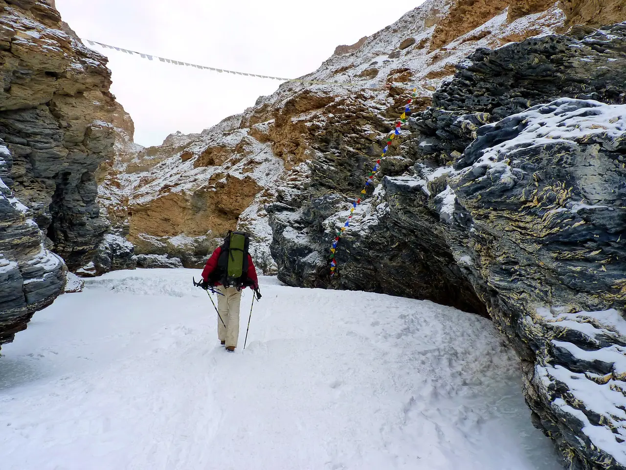 A trekker on the frozen Zanskar river in its snowy gorge