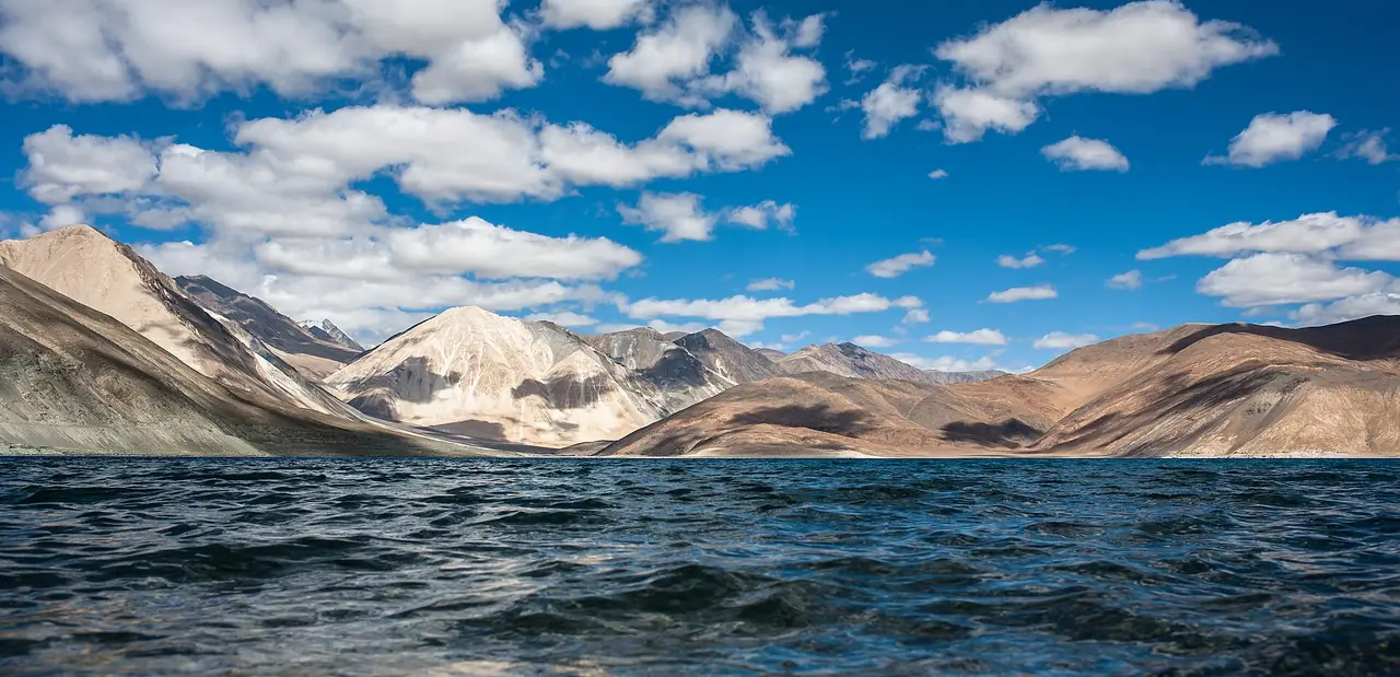 Pangong Tso beneath a sky of scattered clouds