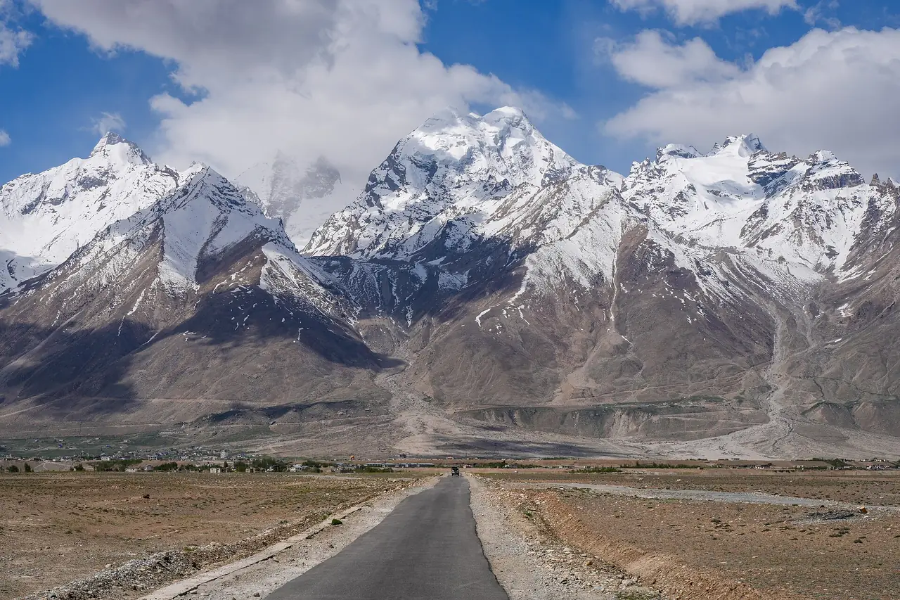 Road through the Zanskar valley beneath snow-capped peaks